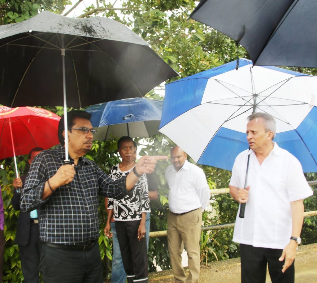 Mininster of Rural Development Senator Kazim Hosein, left, points to the propsed site of the new cremation site at an area called Shipping Road. Also in photo are second from left, PS Desdra Bascombe, Jason Kisson, Communications Department, and Chaguanas West MP Ganga Singh.