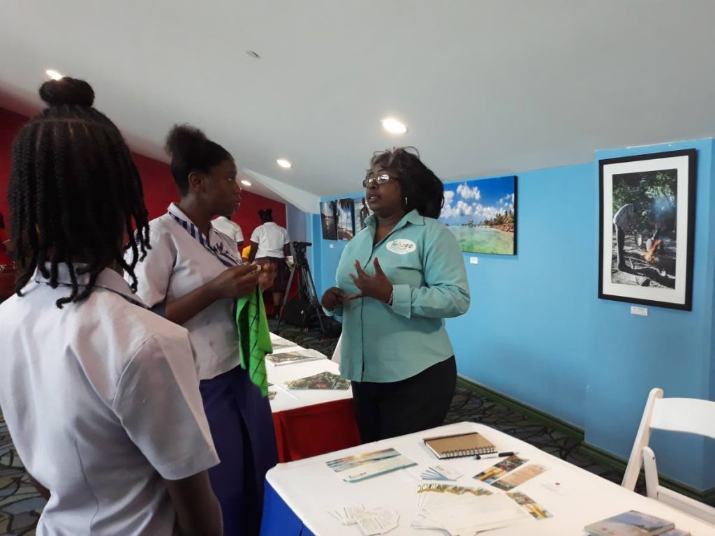 Kaye Trotman, right, President of Tobago Unique Bed, Breakfast and Self-Catering Association, talks to students of the Roxborough Secondary School during a Career Fair hosted as part of Mondays Youth Tourism Symposium at the Shaw Park Cultural Complex.
