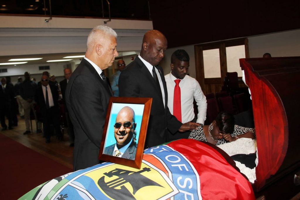 Prime Minister Dr Keith Rowley consoles Perlin Rajpaul wife of deceased councillor Darryl Rajpaul at the Port of Spain City Hall  auditorium yesterday. Looking on are Port of Spain mayor Joel Martinez and Rajpaul’s eldest son  Kedane.