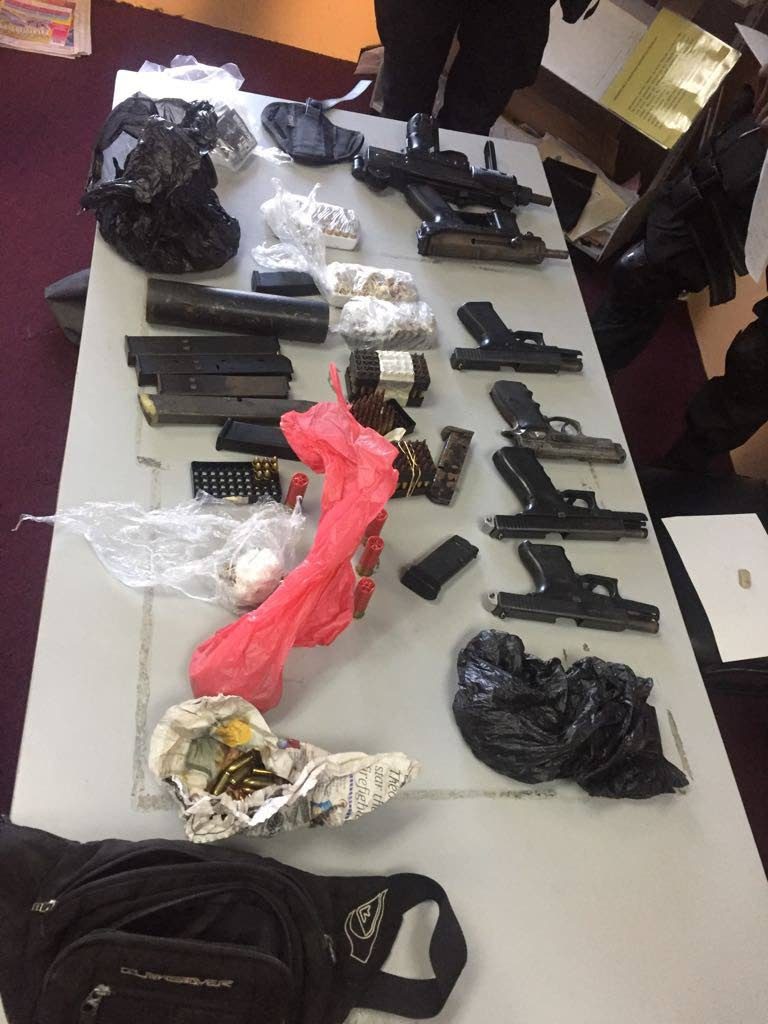 The guns and ammunition found by police at Purcell Street, near Mt Moriah Road in Vistabella yesterday.