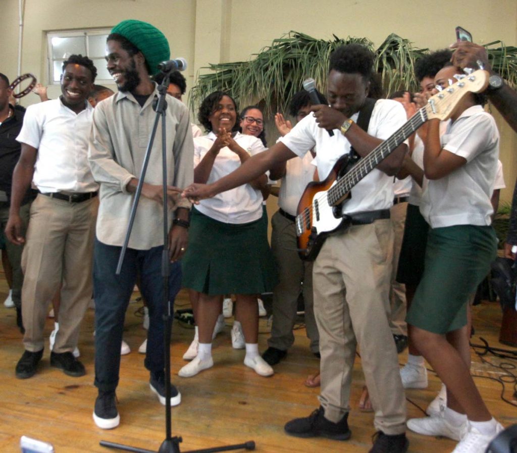 Nathan Joseph, second from right, is overcome with joy as he greets Jamar “Chronixx” McNaughton, second from left, who visited St George’s College in Barataria, yesterday. PHOTO BY ROGER JACOB