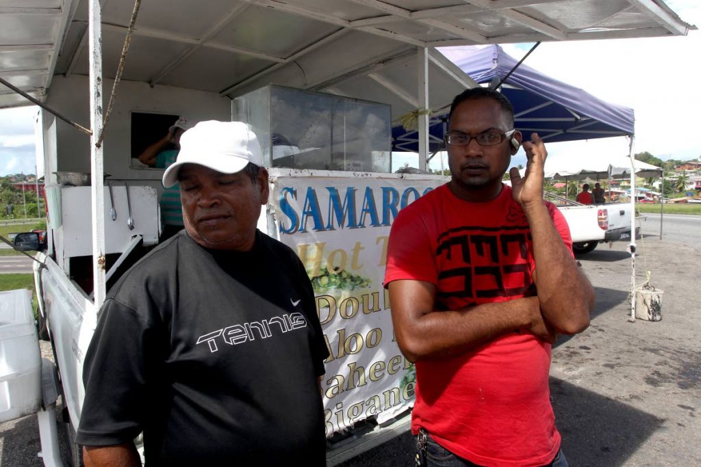 SHOCKED: Doubles vendor Mansram Samaroo and fruit vendor Emmerson Doolan recount the terrifying experience they and others had yesterday when a man ran amok, grabbing a child and attacking police at Tarouba, San Fernando.   PHOTO BY LINCOLN HOLDER