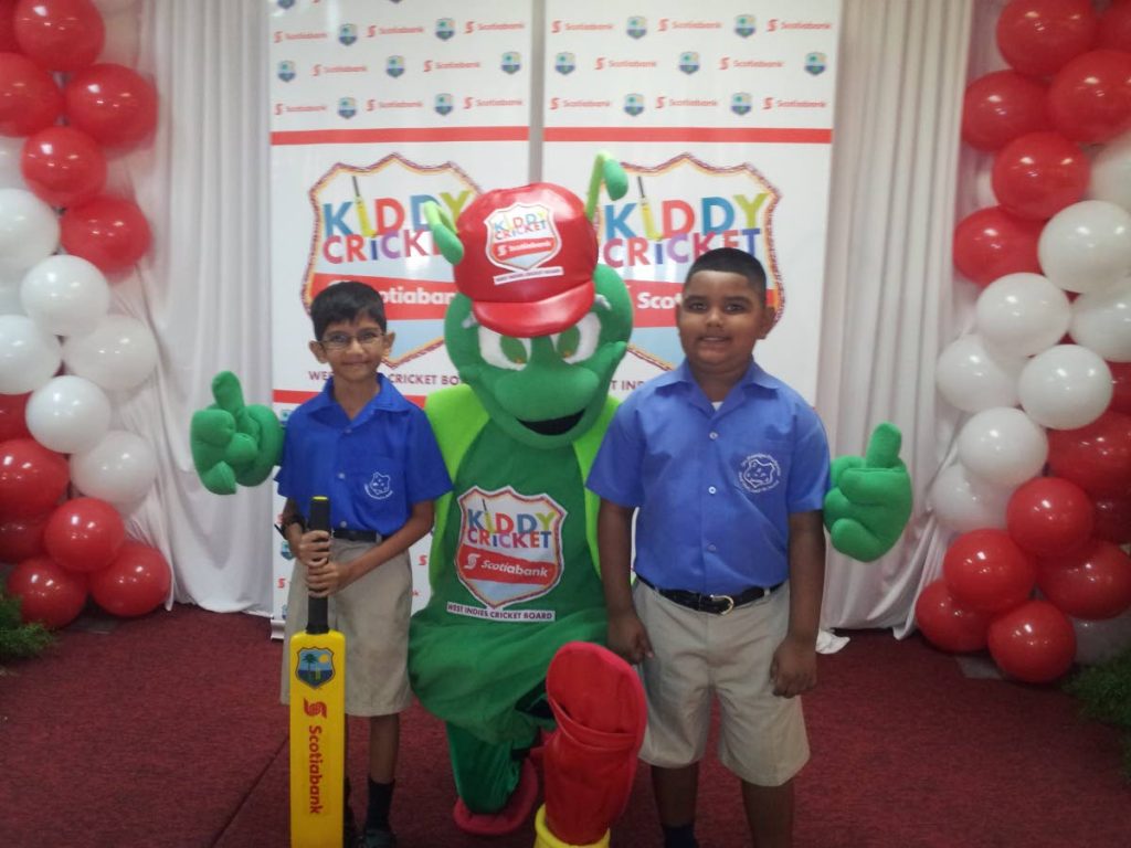San Francique Presbyterian students Riyadh Mohammed, left, and Mathias Ramhit with Scotiabank Kiddy Cricket mascot Chirpy.