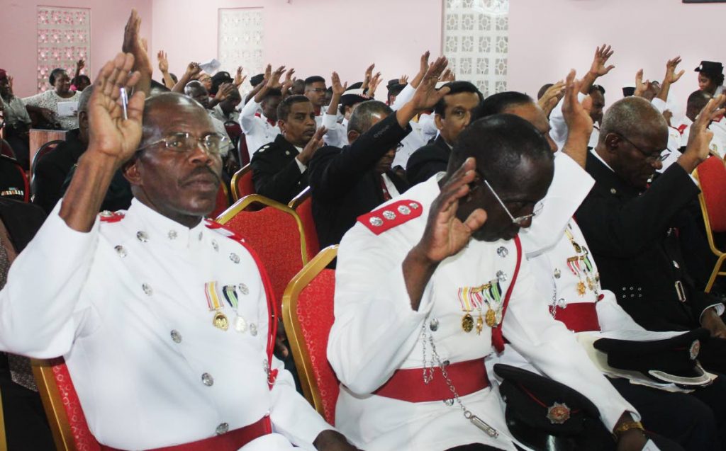 Fired up: Auxiliary fire officers lift up their hands in worship at the African Methodist Episcopal Church, Port of Spain on Volunteer Firefighters’ Day yesterday.  Photo by Enrique Assoon
