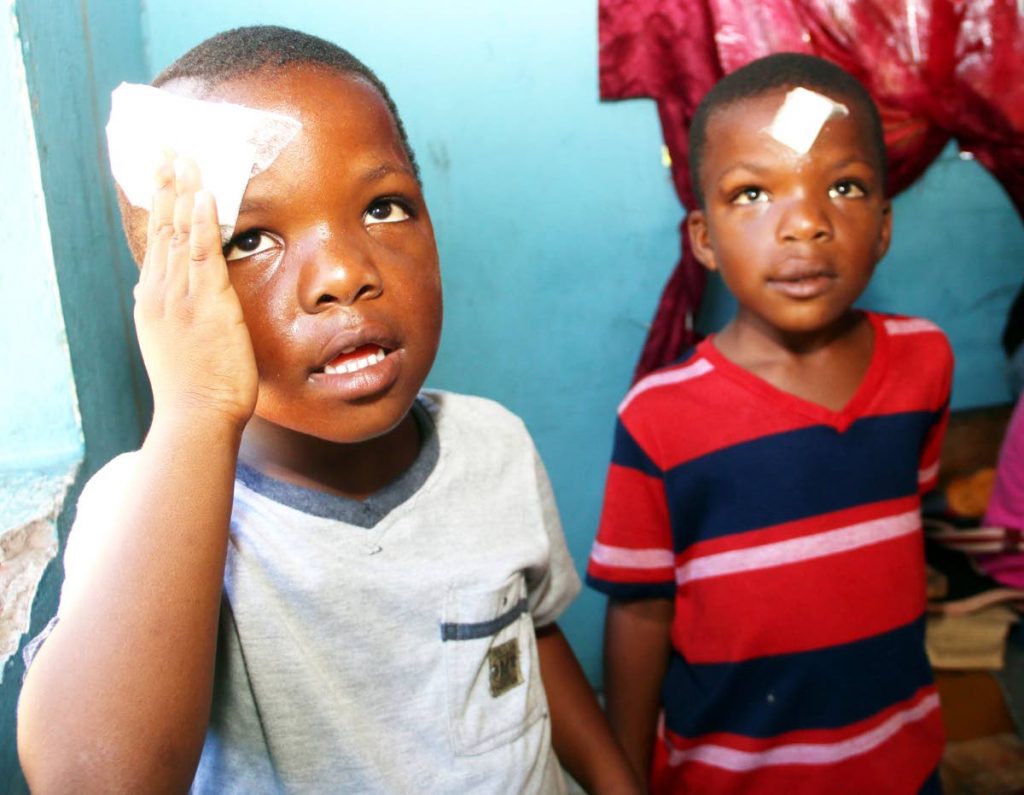 Hurt at school: Ishmael George, left, and and his twin brother Ishmaaeel, at their home in Siparia yesterday, nursing head injuries their father believes a bully inflicted on the five-year-olds at Siparia Boys’ RC School on Monday. Photo by Ansel Jebodh