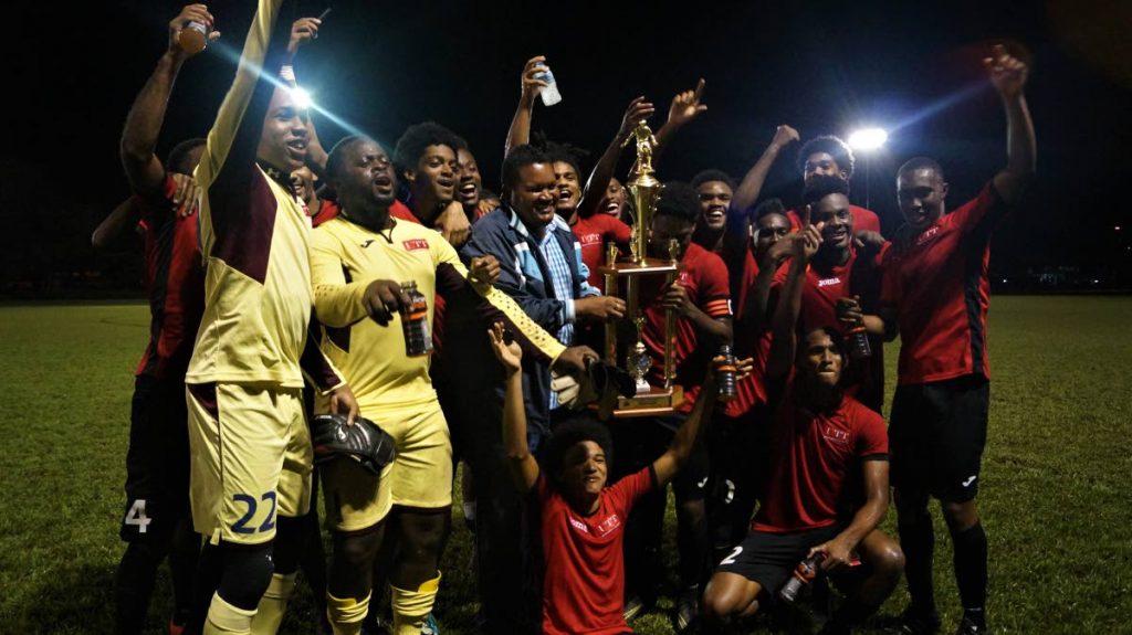 The University of Trinidad and Tobago’s footballers celebrate their tertiary title with Minister of Sport and Youth Affairs Darryl Smith on Monday in UWI, St Augustine.