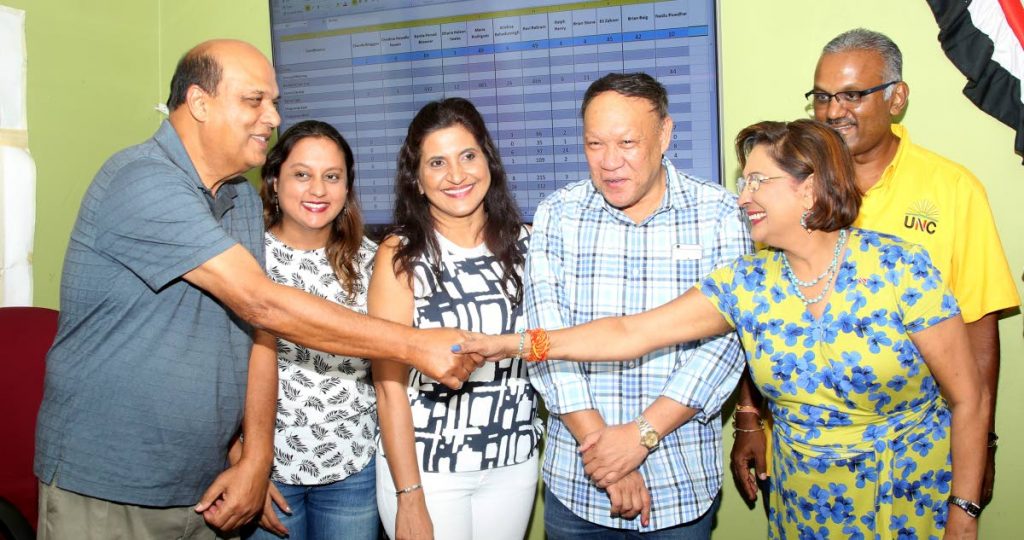 WELL DONE: UNC political leader Kamla Persad-Bissessar is congratulated by Fazal Karim on her victory in Sunday’s internal election.  Looking on are MPs Ramona Ramdial, Vidia Gayadeen-Gopeesingh, David Lee and Rudranath Indarsingh. PHOTO BY VASHTI SINGH.