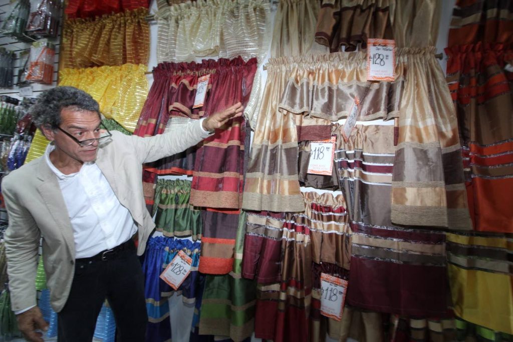Mode Alive CEO Gary Aboud shows off some of the items he has on sale at his newly-reopened Valsayn branch yesterday.
