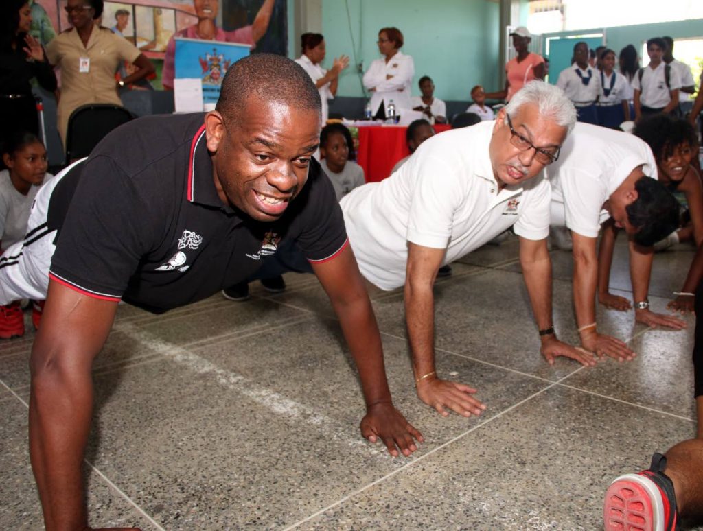 Minister in the Ministry of Education Dr Lovell Francis, left, along with Minister of Health Terrence Deyalsingh, centre, and MP for fyzabad Dr Lackram Bodeo do push ups at the Fyzabad Anglican Secondary School yesterday.