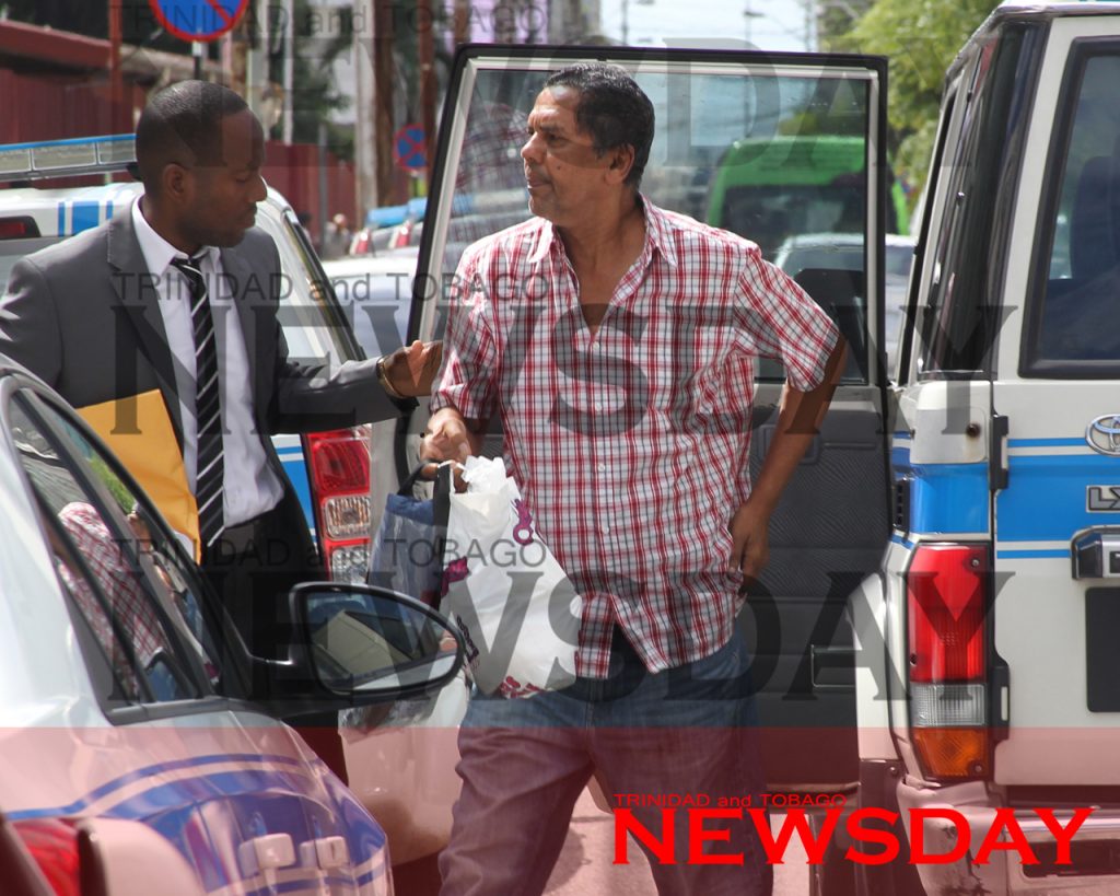 ACCUSED: Ramnath Ramdhan, right, the owner of a pharmacy, arrived at the Port of Spain Magistrates Court this morning to answer to five counts of rape. PHOTO BY RATTAN JADOO