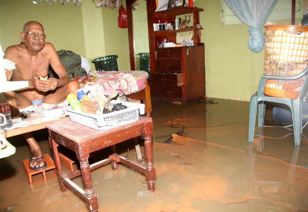 Flashback: Joseph Gonzales sits on his bed in his flooded home in La Romaine triggered by rainfall in this October 6 file photo.