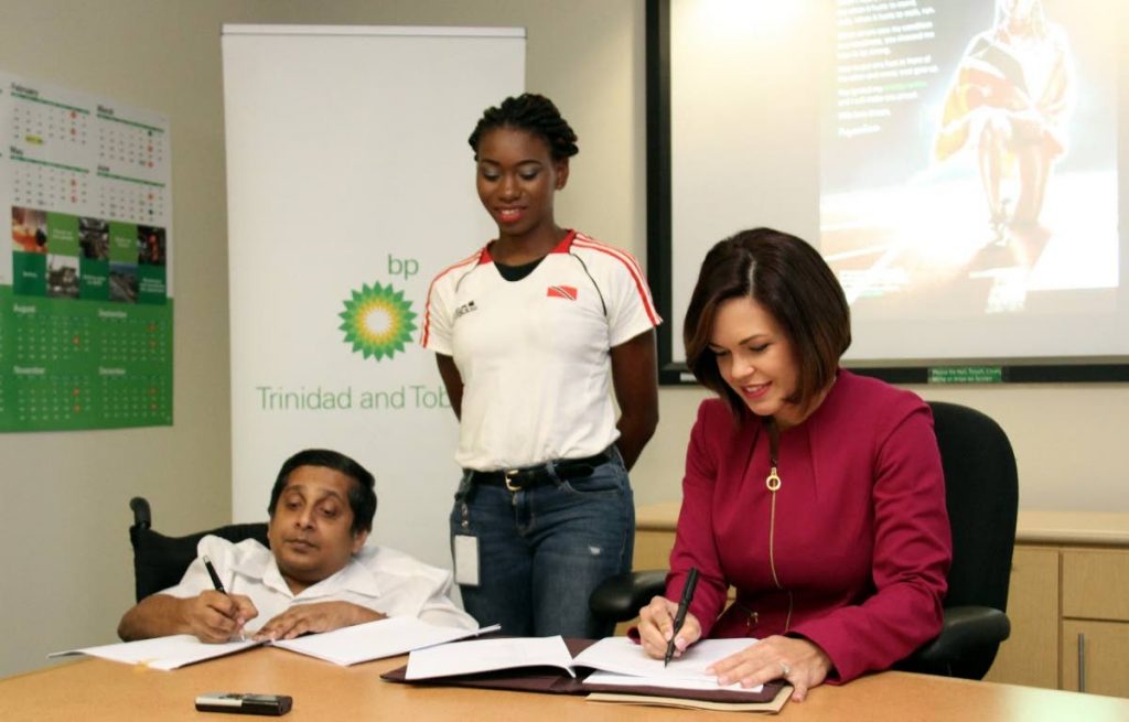 TT Paralympic athlete Nyoshia Cain, centre, looks on as vice-president Corporate Operations at BPTT Giselle Thompson, right, and president of the TT Paralympic Committee (TTPC) Sudhir Ramessar, sign a partnership between BPTT and the TTPC at the BPTT office in Port of Spain, yesterday.