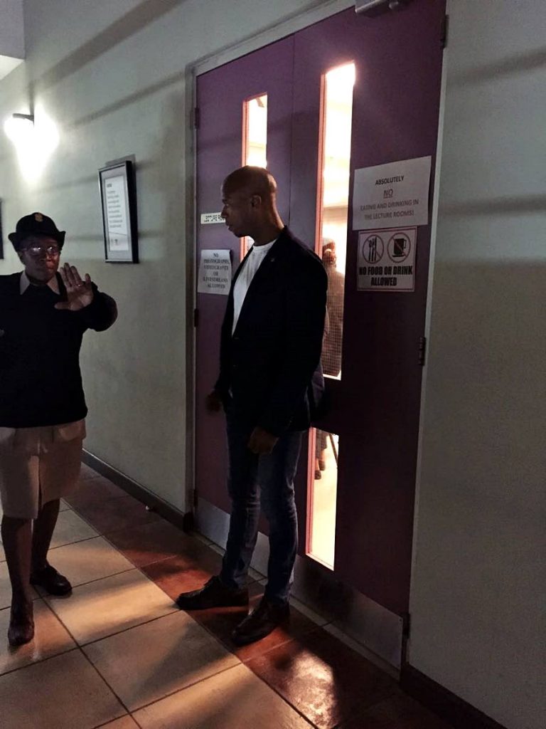 OFF YOU GO: Director of the Cross Rhodes freedom Project (CRFP), Shabaka Kambon, is seen being told to leave the UWI St Augustine Campus. PHOTO COURTESY THE CROSS ROADS FREEDOM PROJECT