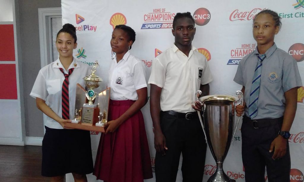 READY FOR BATTLE: Team captains (left-right) Leah Dos Santos (Bishop Anstey), Latifha Pascall (Pleasantville), Renaldo Boyce (San Juan North) and Judah Garcia (Shiva Boys) pose with the girls and boys Intercol trophies at a press conference on Friday at the VIP Lounge, Hasely Crawford Stadium, Mucurapo.