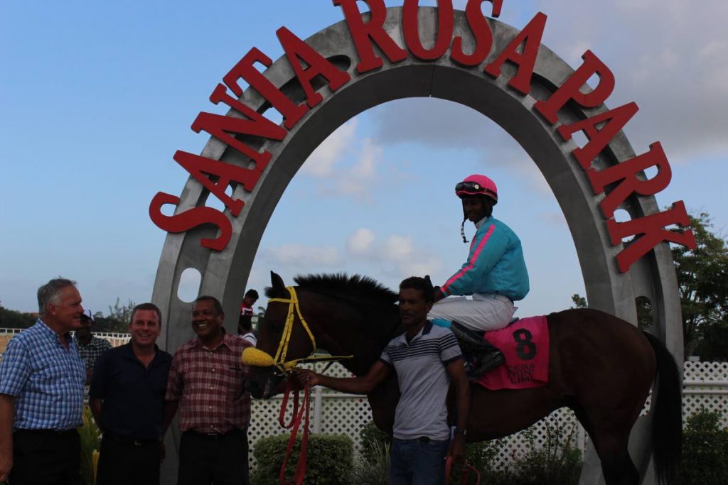 THISONESFORRON with jockey Keron Khelawan is toasted in winner’s circle by trainer John O’Brien (from left) and owners Roger Hadeed and Gerry Harding after winning the Stewards Cup at Santa Rosa Park, Arima, yesterday.