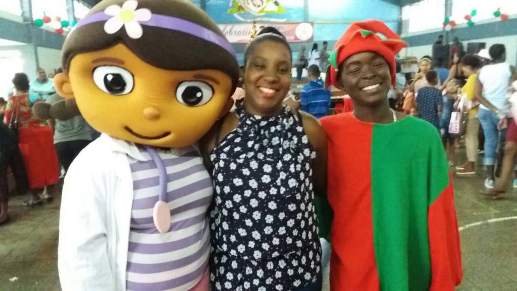 Natoya King, centre, pose with Elf and Doc Mc Styffin at Rhands Credit Unions Christmas party last Sunday at the Mason Hall Secondary school.