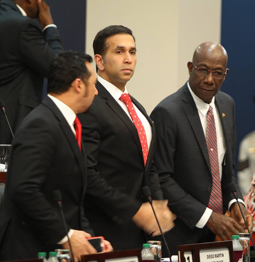 IN A ROW: Attorney General Faris Al-Rawi is flanked by Minister in the Ministry of the Attorney General Stuart Young and Prime Minister Dr Keith Rowley at yesterday’s sitting of the House of Representatives.   PHOTO BY RATTAN JADOO
