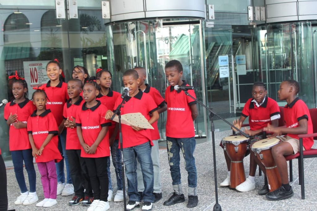 Students from the Our Lady of Laventille RC primary school sings Christmas carols outside the Education Ministry at St Vincent Street, Port of Spain on Thursday.