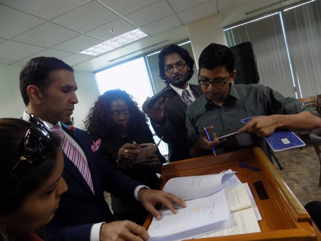 Attorney General Faris Al-Rawi, second from left, shows reporters sections of the anti-gang bill after a press conference at the Parliament Tower C yesterday.