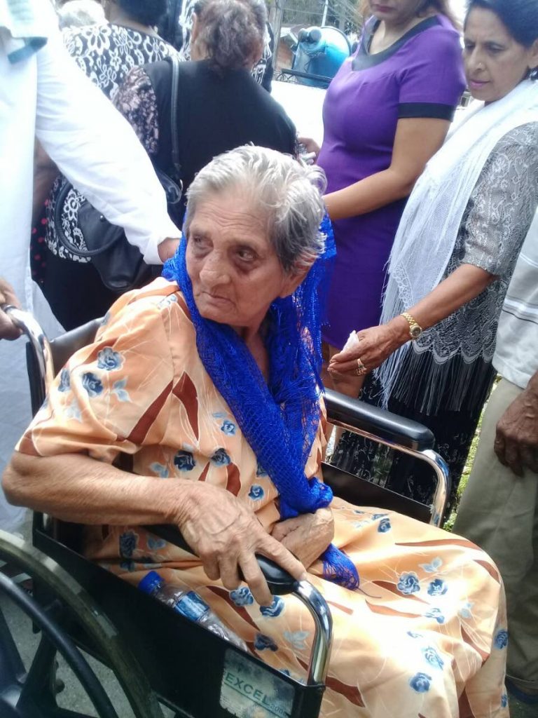 Ruby Samaroo, 75, goes to the funeral of her son, Ganesh, at Perservance Village, Couva yesterday.