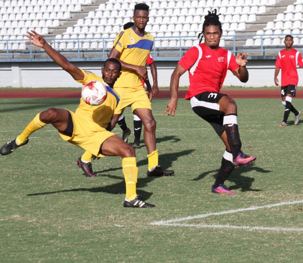 A FC Santa Rosa player (left) attempts a shot on goal while UTT defender Jean-Luc Rochford looks on, during yesterday’s Super League match.
