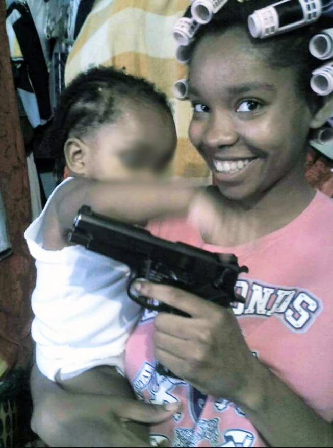 WHAT MADNESS? Acting Commissioner of Police Stephen Williams has ordered an investigation after this photo, showing a policewoman waving a pistol while holding a baby, went viral on social media yesterday.
