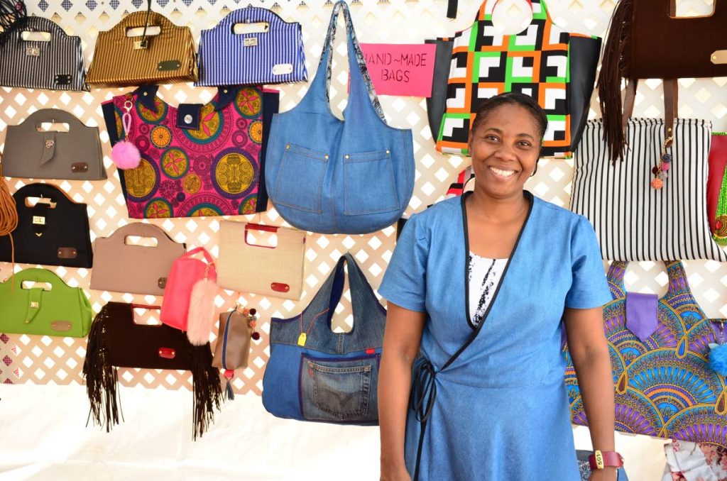  Claudette Daniel shows off he handmade bags at her booth at the Christmas Village on the Milford Road Esplanade on Monday.