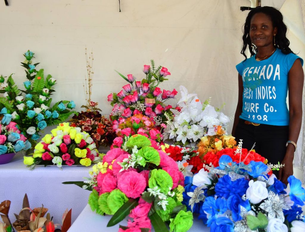 Portia George shows off her range of silk flowers at the Christmas Village on the Milford Road Esplanade on Monday.  