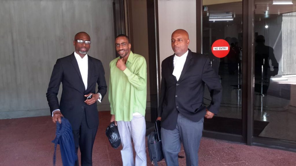Dwayne Bramble, at centre, who was freed of a murder charge, leaves the Hall of Justice, Port of Spain, with his attorneys Kelston Pope, left, and Evans Welch, right. 