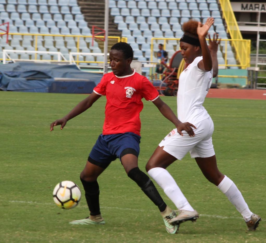 Trinidad and Tobago women’s Under-20 player Kedie Johnson, right, defends as Jamal Durant of a North Under-15 boys team shields the ball in a practice match held recently at the Hasely Crawford Stadium, Mucurapo.