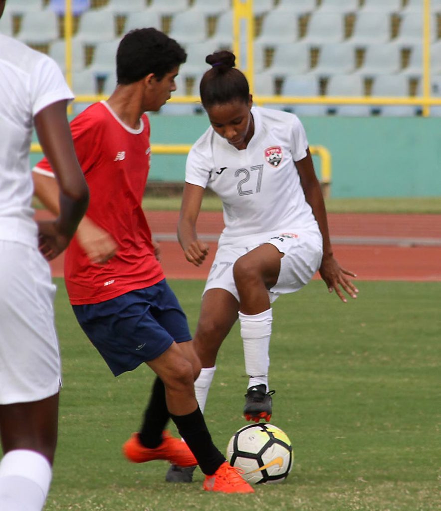 Trinidad and Tobago’s Raynicia Charles, right, on the ball against Andrew De Gannes in a friendly match between the national women’s Under-20 team vs a North U-15 boys team at the Hasely Crawford Stadium, Mucurapo.