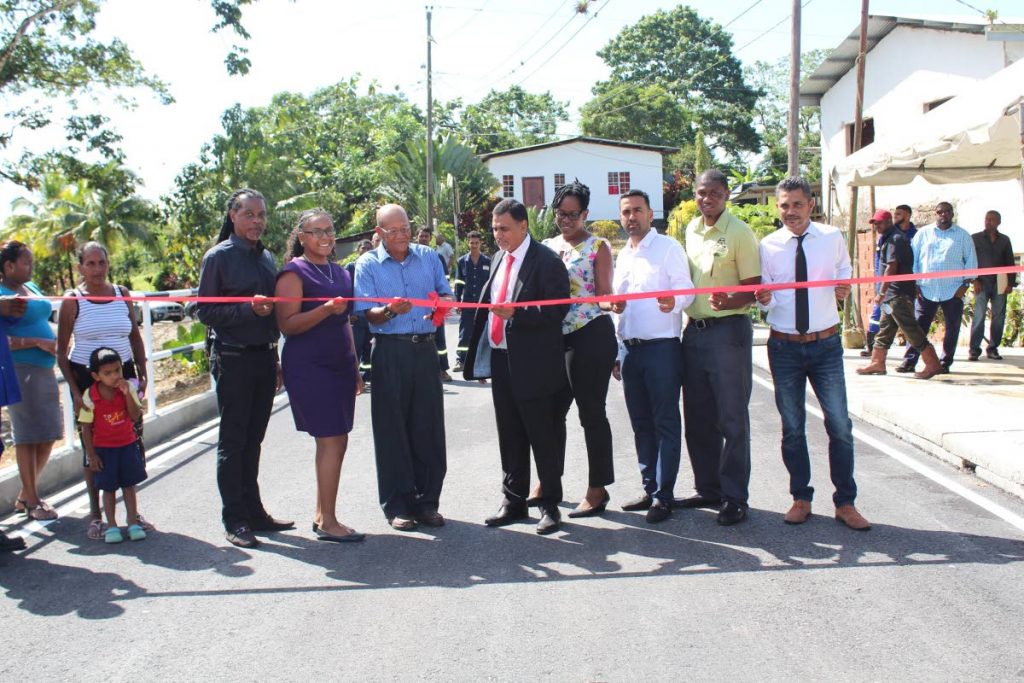 Works Minister, Rohan Sinanan and PNM constituency vice chairman Felix Clarke cut the ribbon to officially reopen the John Dillon Road (also called the Mundo Nuevo Road), Talparo, while contractor Arvin Kalloo, third from left, looks on.