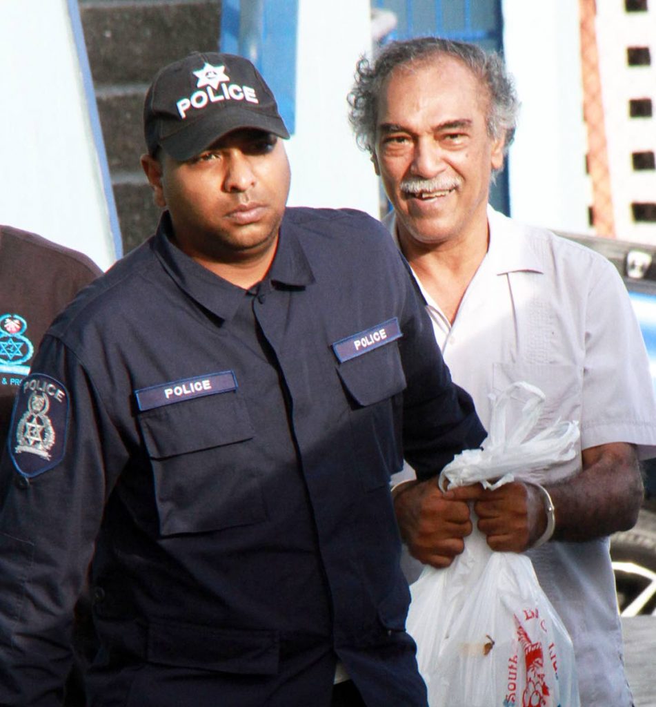 Dr Ronald Budhooram is escorted from court. PHOTO BY ANIL RAMPERSAD. 