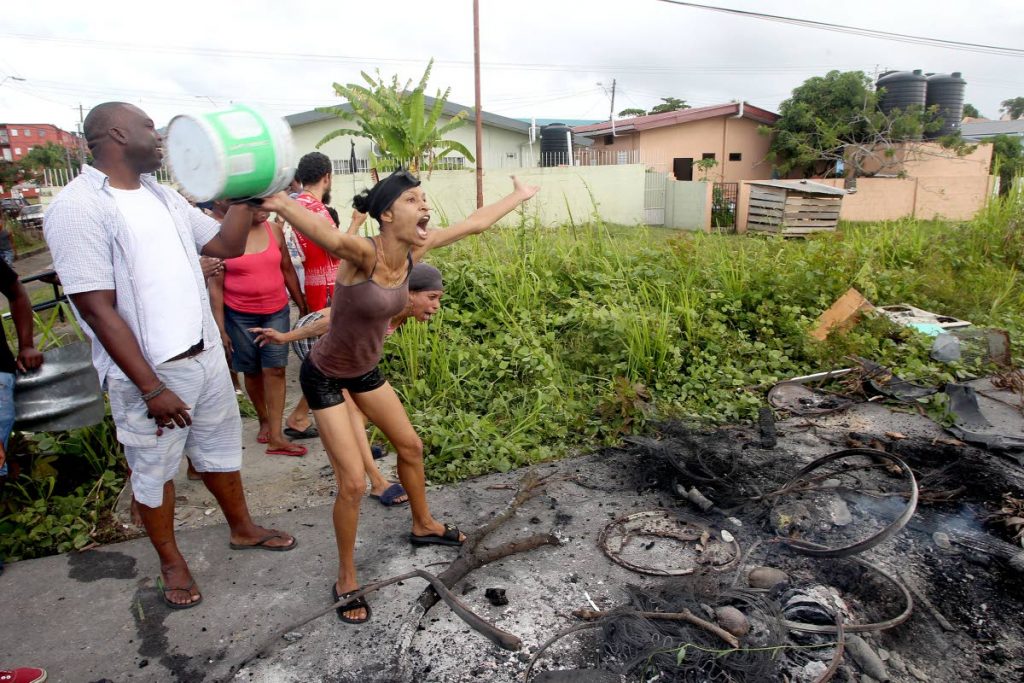 We want waaaater!: Two women vent their frustration over a lack of water in Maloney Gardens yesterday after a protest where debris was set on fire and scattered across Churchill Roosevelt Highway yesterday. Photo by Lincoln Holder