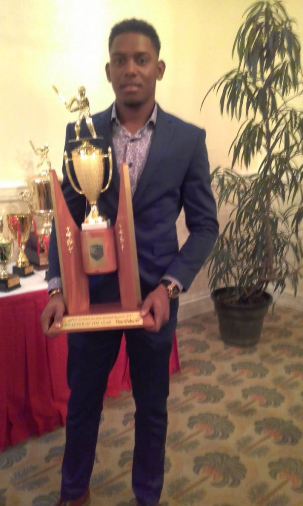 Tion Webster poses with his Men’s Cricketer of the Year trophy at the Queen’s Park annual awards on Friday at the Queen’s Park Oval, St Clair.
