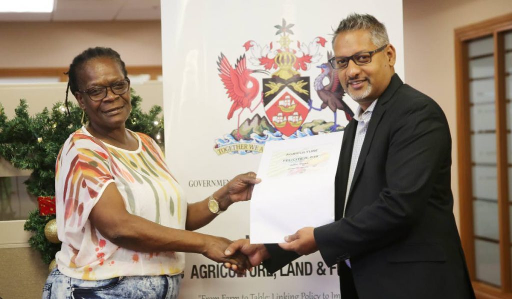 YOUR LEASE: Mearle Thomas receives her lease from Agriculture, Land and Fisheries Minister Clarence Rambharat yesterday in Chaguanas. PHOTO BY VASHTI SINGH