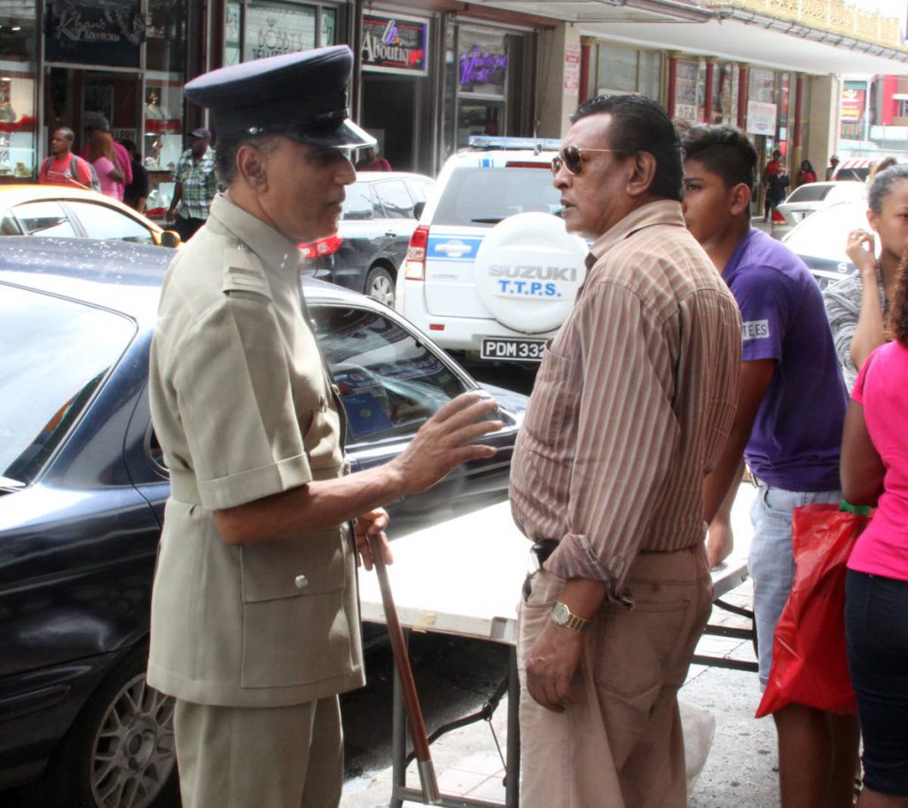 Inspector Harvey Jawahir speaks with people at Frederick Street in Port of Spain as members of the City Police embarked on an exercise to remove illegal vendors for Christmas 2017.