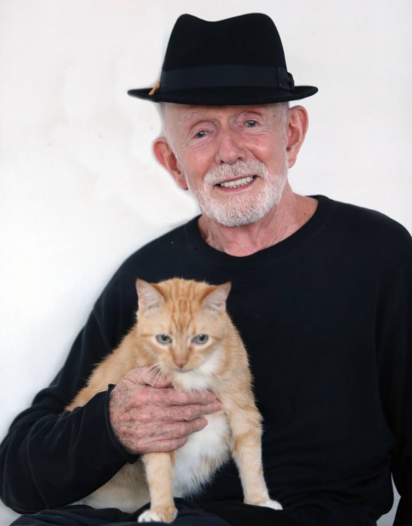 Mas icon Peter Minshall at home last week with his cat Mauvais. PHOTO BY AZLAN MOHAMMED