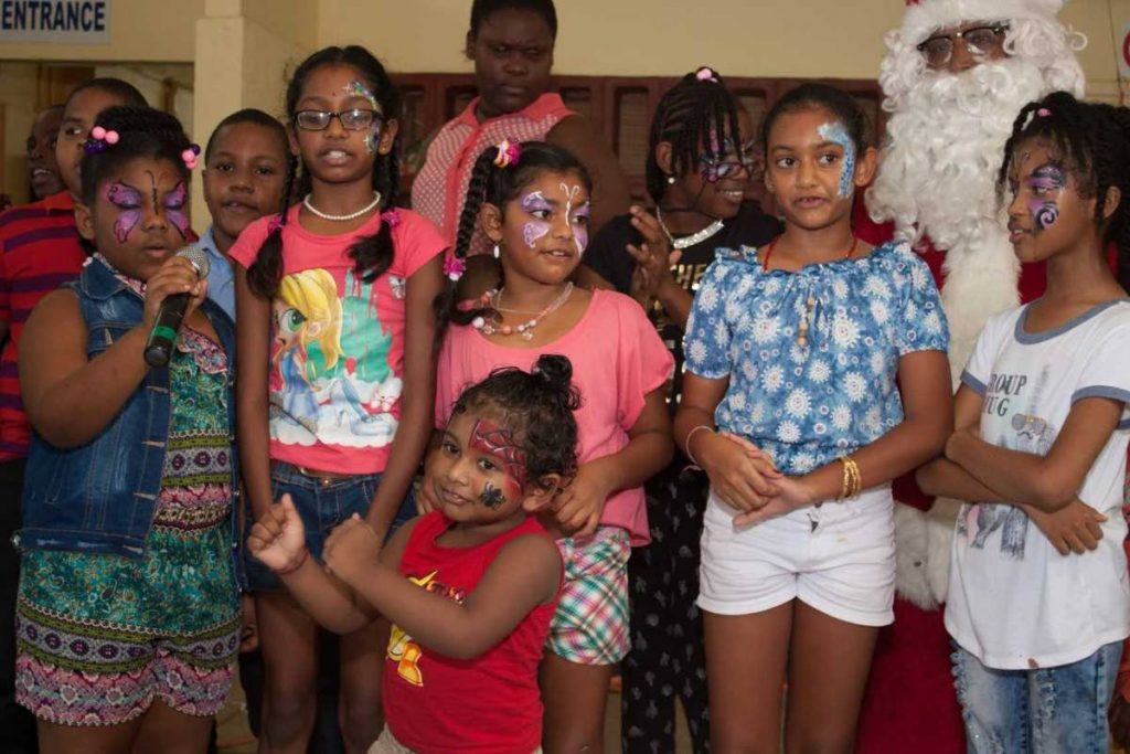Children sing Christmas carols after getting their faces painted.