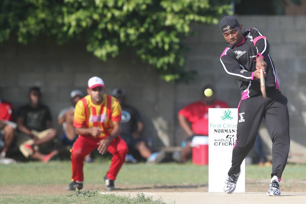 S&S’s Terrance Hinds swings for a shot while Reload’s wicket keeper Micheal Harry prepares to react , during the Finals of the First Citizens Norman’s Windball Cricket League 2017 recently. Premier  League Division between S+S Web Source (black) and Reload (yellow and orange) at the Tacarigua Community Centre, Tacarigua. Final score: S&S won by 59 runs.