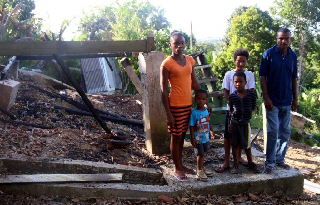 HOMELESS: Family members from left, Phyllis Daniel, Roger Guy, four, Ricardo Daniel, six, Orlando Guy, 11, and Separion Guy, stand near the ruins of their home in Caratal.