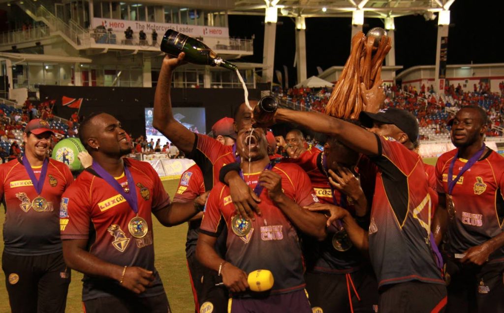 Trinbago Knight Riders captain Dwayne Bravo, centre, guzzles champagne after his team won the 2017 Caribbean Premier League final earlier this year at the Brian Lara Academy, Tarouba.