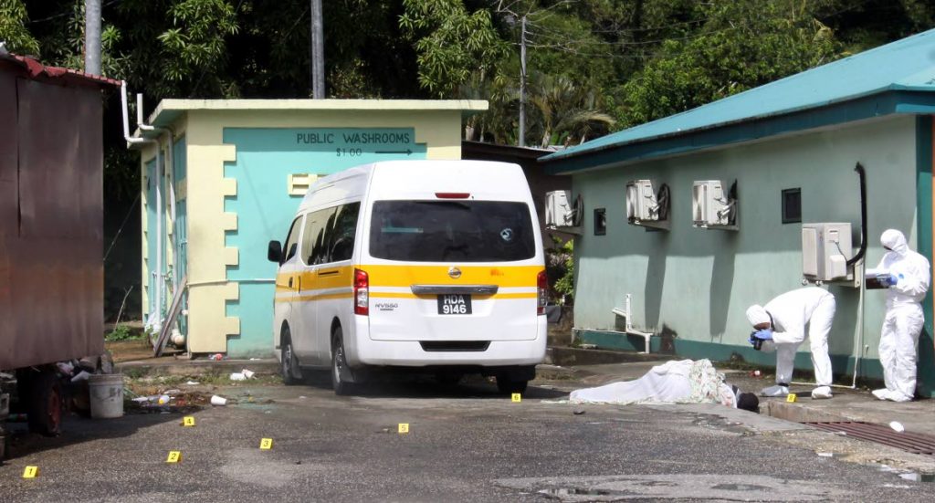 GUNNED DOWN: Crime scene investigators photograph Dwayne Knight, inset, who was shot dead at the maxi taxi terminal in Patna Village, Diego Martin yesterday. A bullet pierced the back window of the maxi next to the body. PHOTO BY ANGELO MARCELLE.