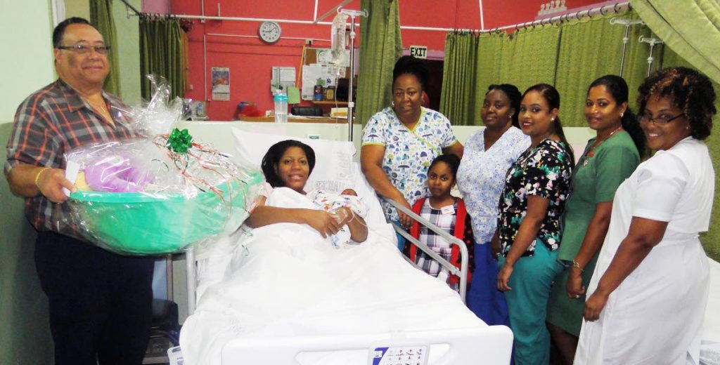 BUNDLE OF JOY: Sangre Grande Hospital Chief Executive Officer Ronald Tsoi-a-Fatt (left) presents a hamper to Shanna Forrester-Le Sendre who gave birth to the only baby for Christmas Day 2017. Also at her bedside (from left to right) are Camille Moore, midwife, and her daughter Amara, midwives Sebla La Rose-Orr and Tammika Seecharan, Patient Care Assistant Rajistrie Sammy and Registered Nurse Gillian Harris.