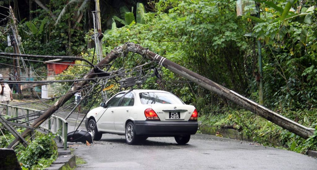 A car manoeuvres through fallen utility lines at Ariapita Road, St. Ann's.