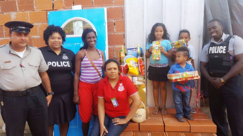 Officers of the Marabella police station with Kay Greene and her children at Bayshore, Marabella.