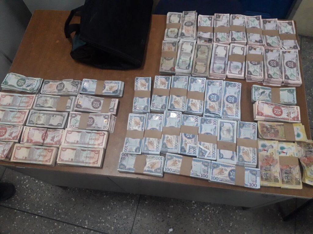 RECOVERED: Wads of cash totalling $220,000 displayed at the Couva police station after it was found in a washing machine. The money was stolen on the weekend from Super Industrial Services (SIS) in Couva.