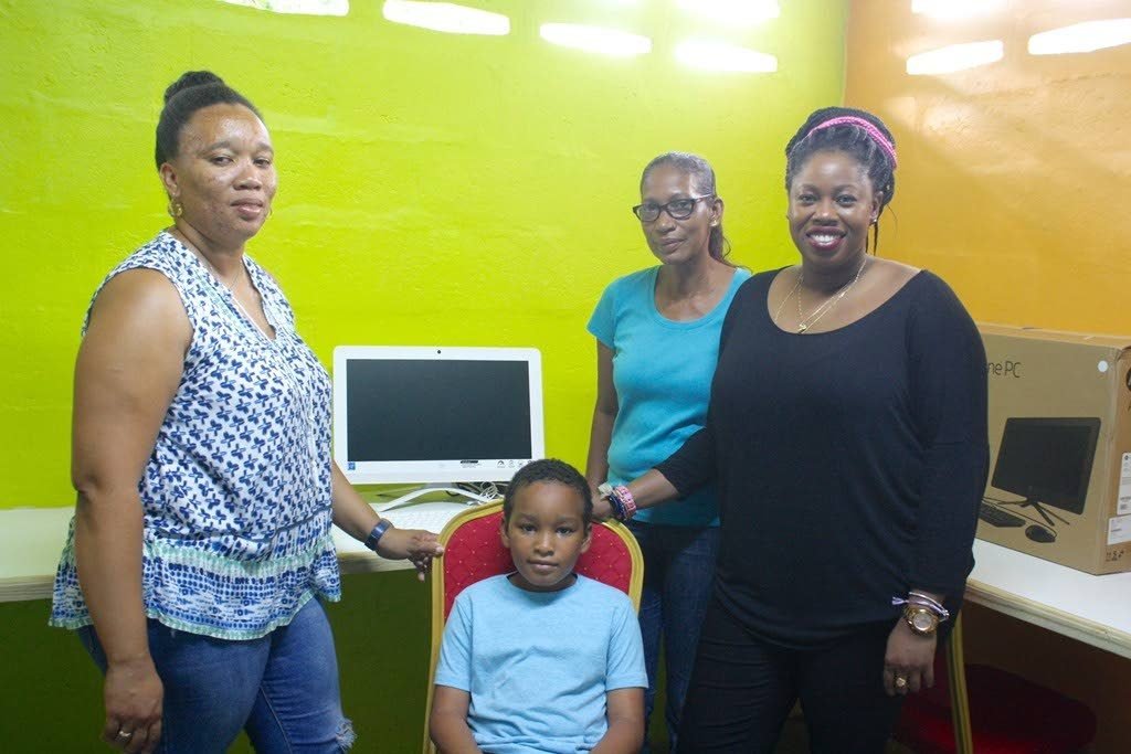 This little boy is flanked by Mary Reyes, president of the El Luengo Community Council, from left, Catherine Noreiga, vice president of the council and Cindyann Currency, Digicel Foundation’s operations manager
