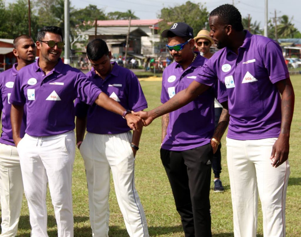 CHARITY T20: Daren Ganga (left) greets Kevon Cooper (right) as Sunil Narine (centre) looks on before they all took part in the Daren Ganga Foundation Charity T20 cricket match at the Daren Ganga Recreation Grounds in Barrackpore yesterday.