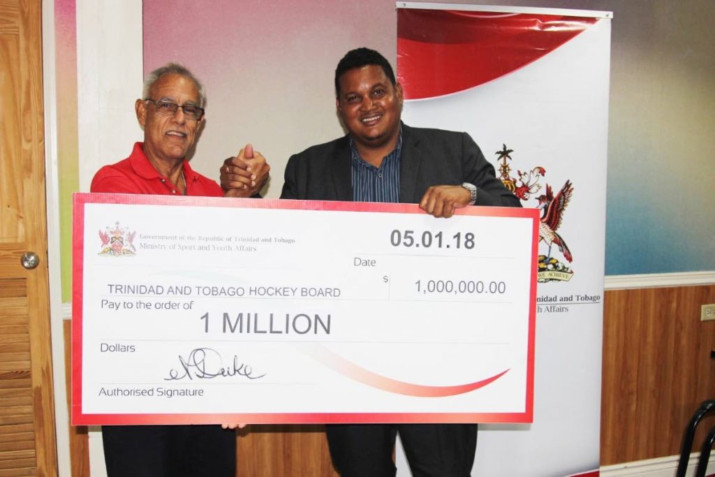 Minister of Sport and Youth Affairs Darryl Smith, right, presents 
president of the Trinidad and Tobago Hockey Board Douglas Camacho with a cheque at the TT Olympic Committee head office, on Friday.